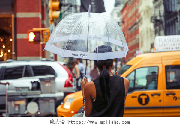 雨天撑着伞现在忙碌街道的女人